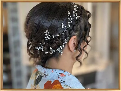 Un raccolto di ricci scuri con un tralcio di perle e cristalli tra i capelli.